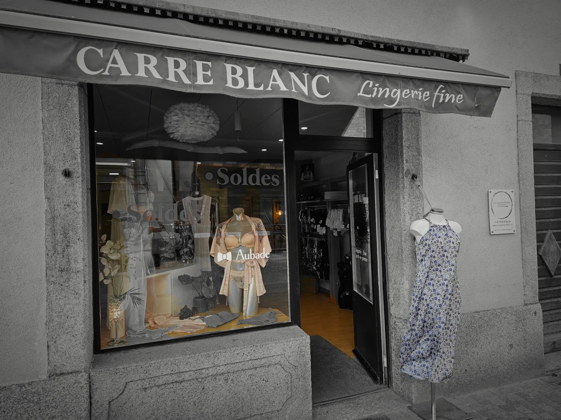 Vitrine de la boutique Carré Blanc dans une rue pavée avec des mannequins portant de la lingerie ou des maillots de bain