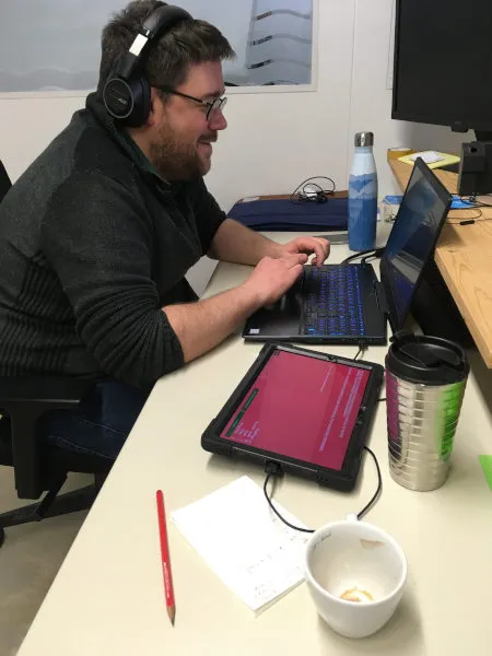 Loïc développant avec son ordinateur et une tablette l'application React Native