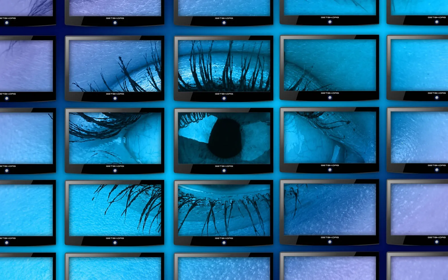 Somebody is watching you... Un oeil affiché sur un mur d'écrans bleu-violet